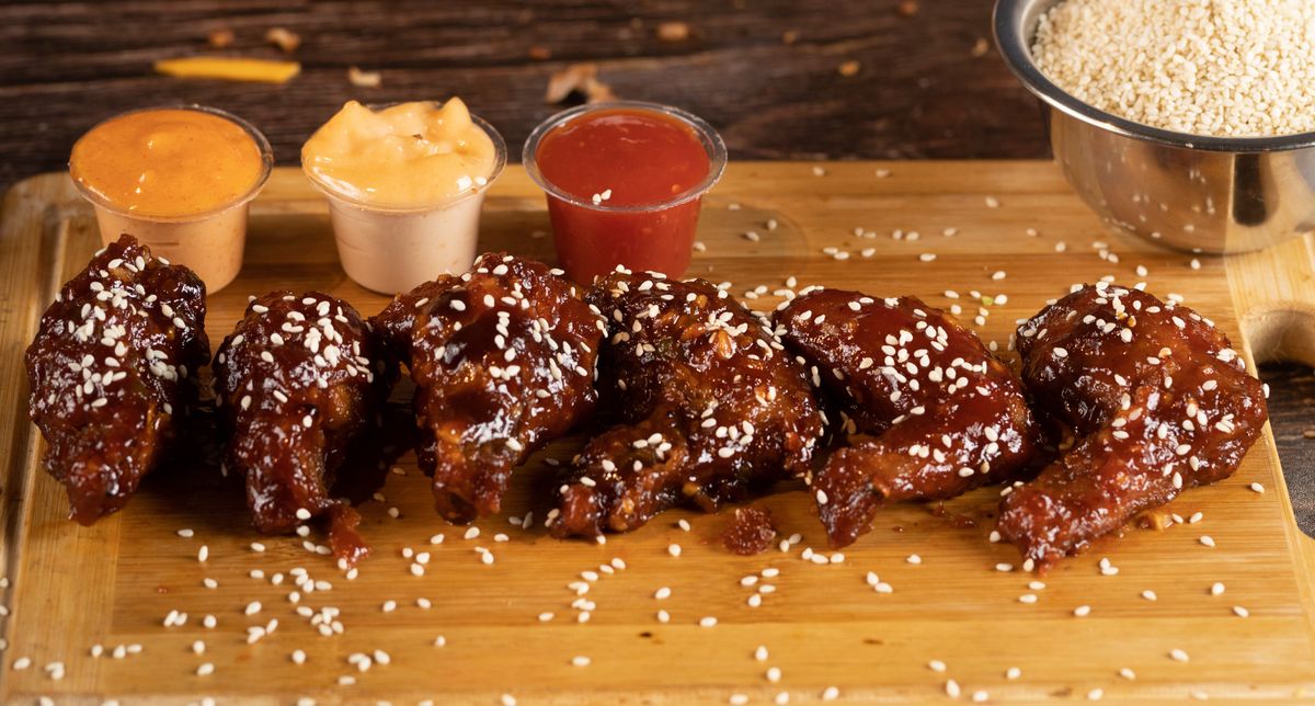Sauced chicken wings with sesame seeds and dipping sauces