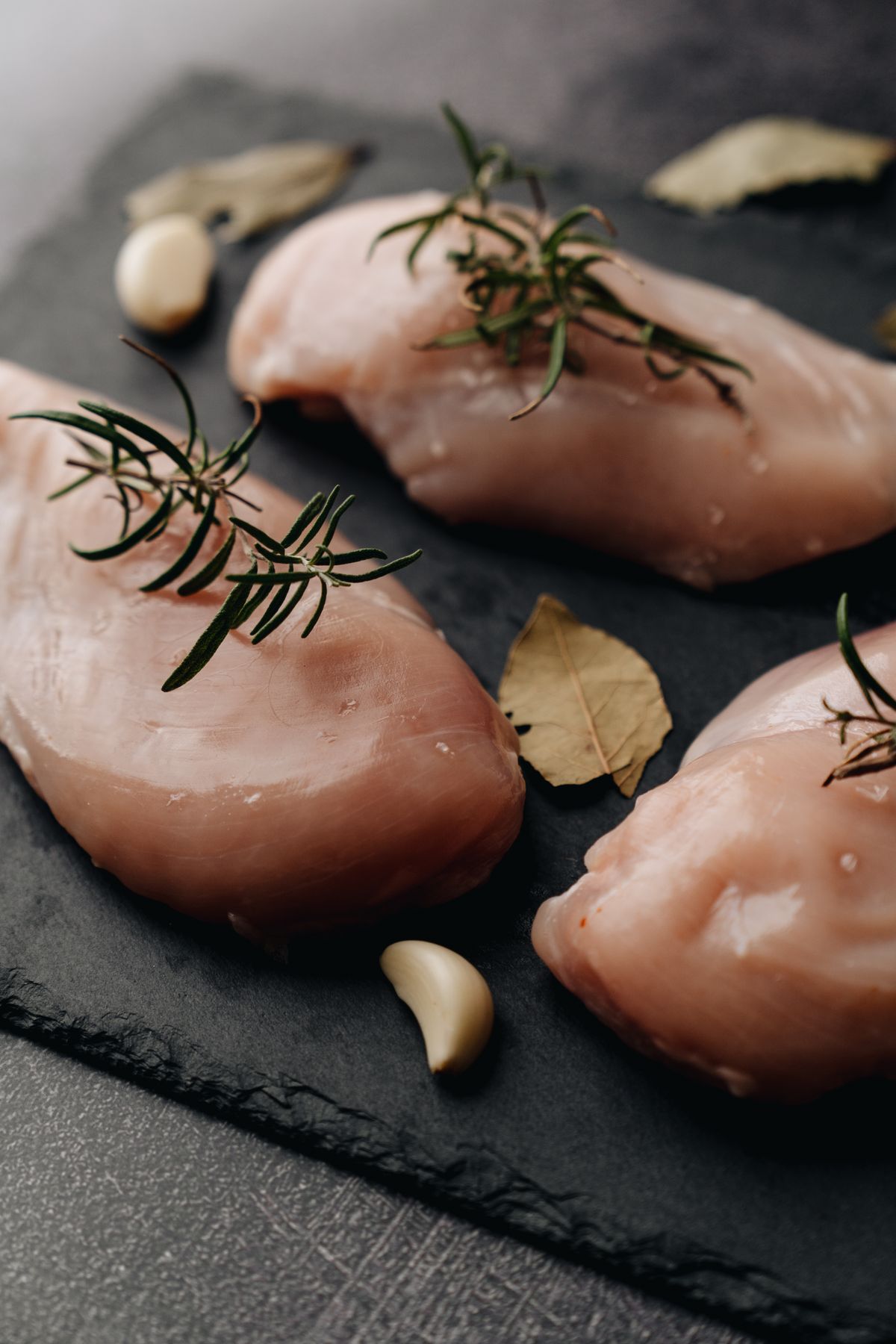Raw chicken breast with rosemary before cooking